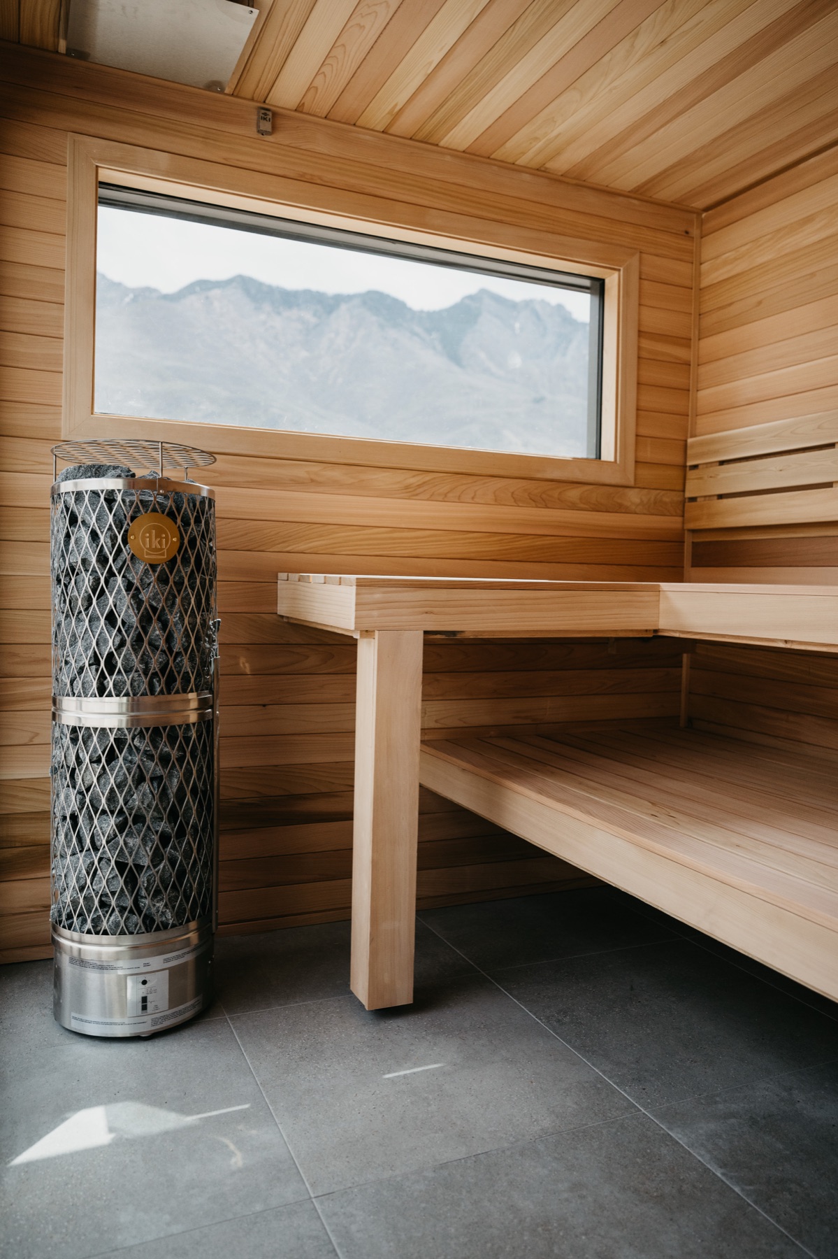 IKI Pillar 9kW heater beside the cedar bench, mountain view through the window