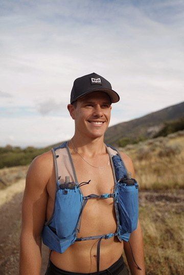 Cole in a running vest on the trail