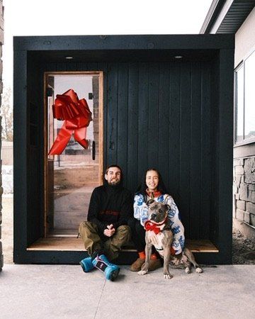 An early owner and his wife with a red bow on the door