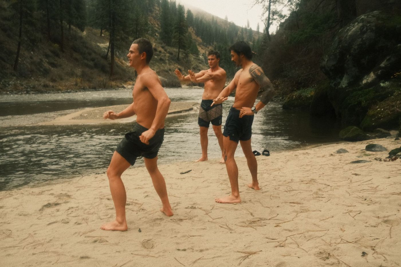 Three men on a river sandbar after cold water