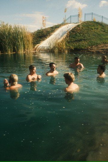A group neck deep in a spring fed pond