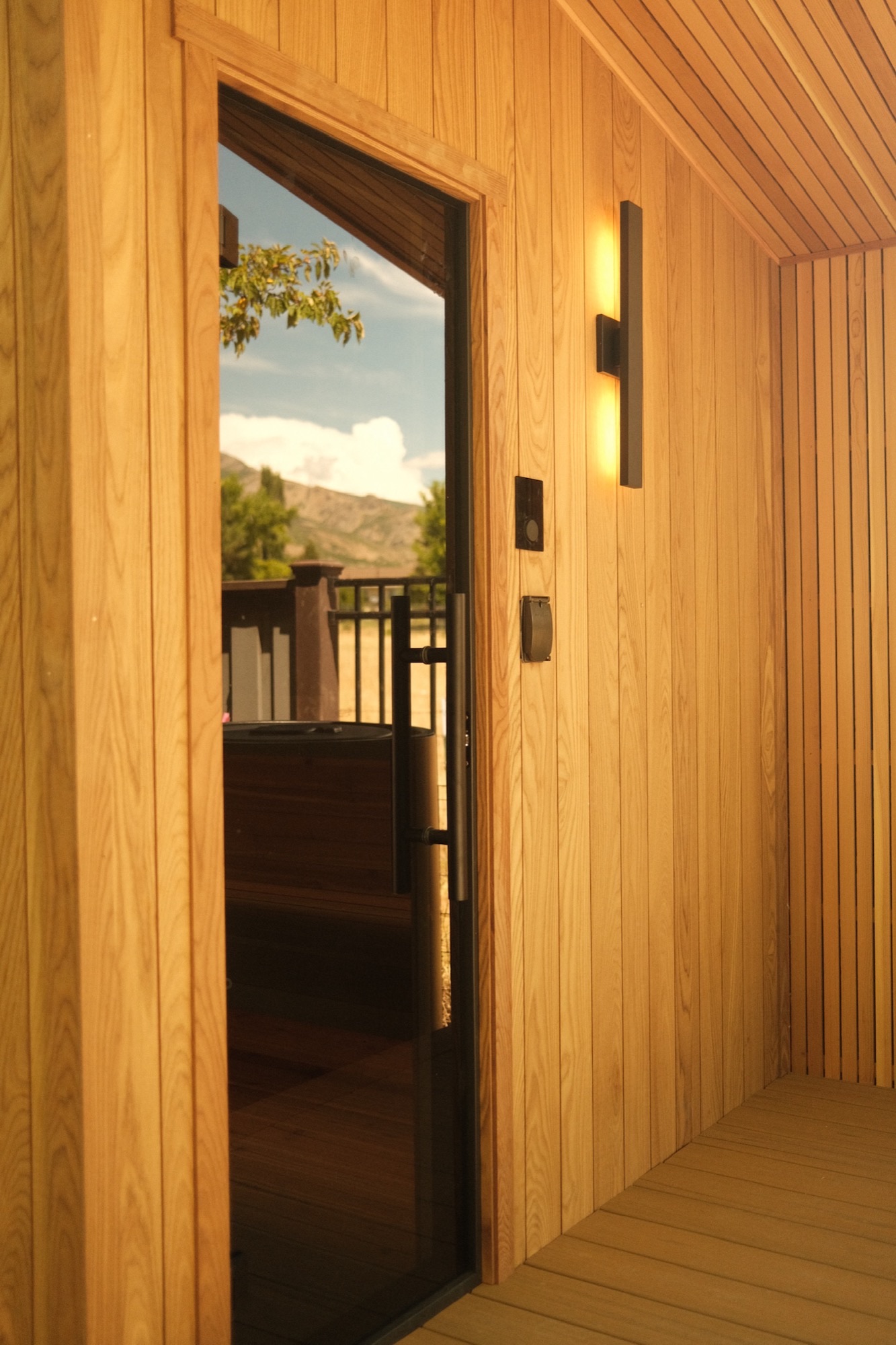 Glass door and blackened sconce on the cedar porch