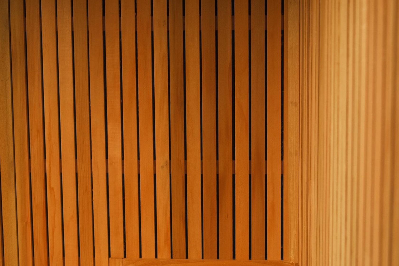 Slatted cedar wall washed in warm 2200K light