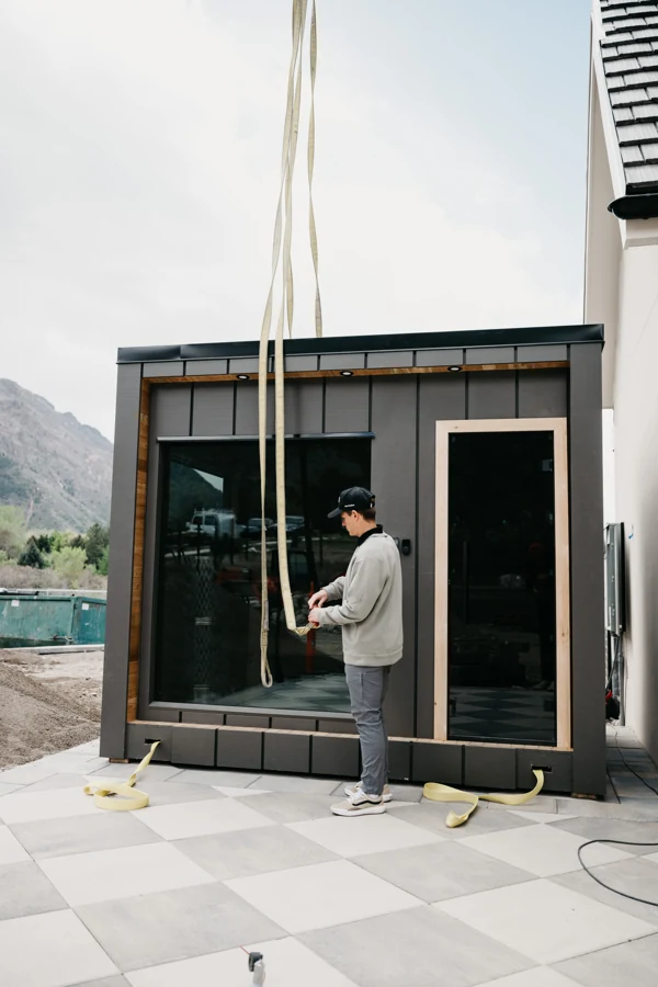Installation crew guiding the 212 Essential into place beside the patio
