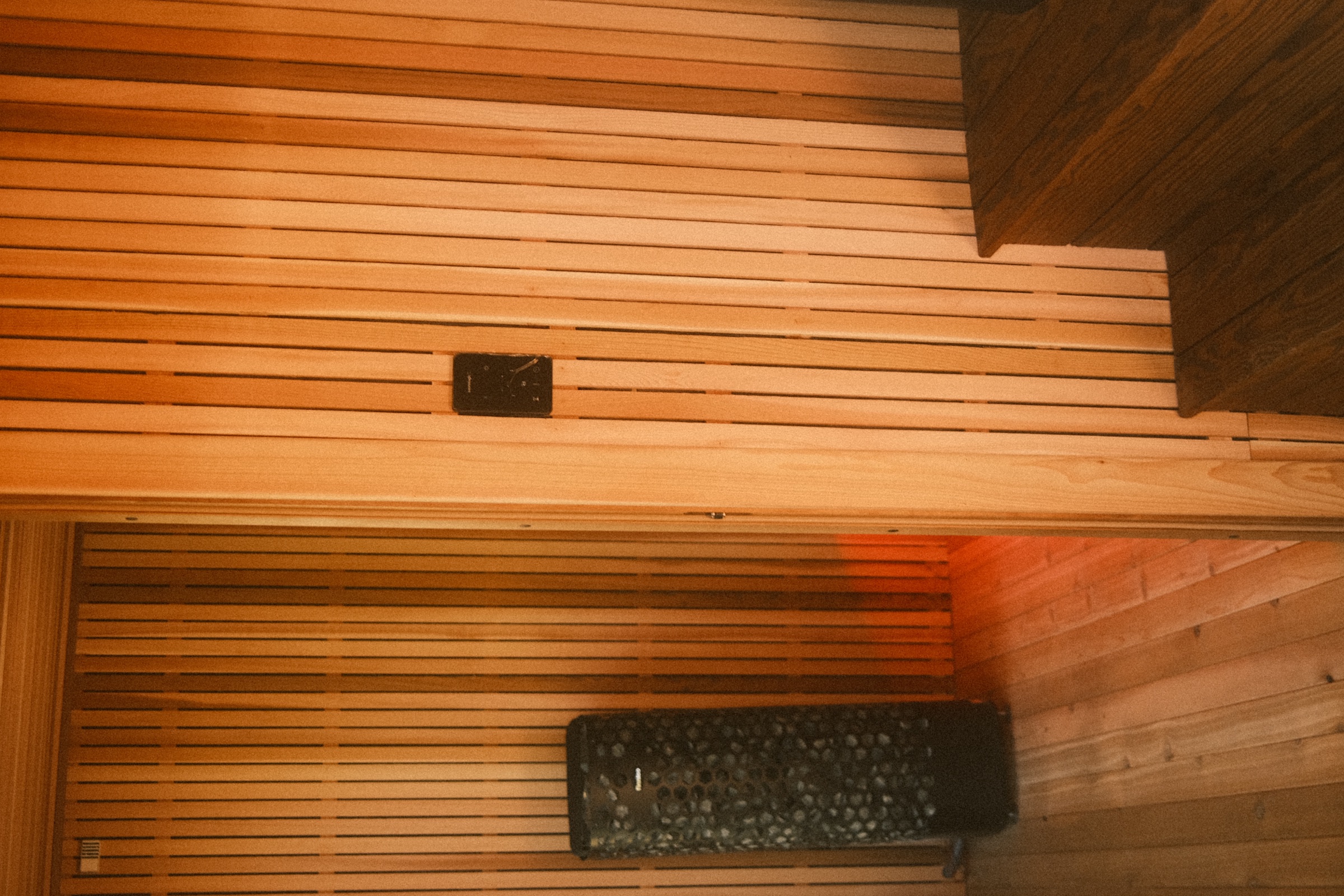 Wide interior view of cedar bench tiers and the sauna heater
