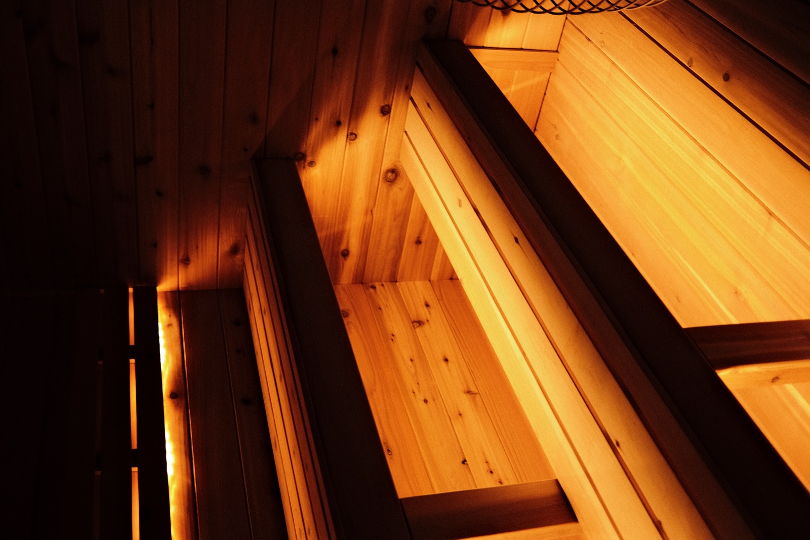 Cedar sauna benches under a warm light strip
